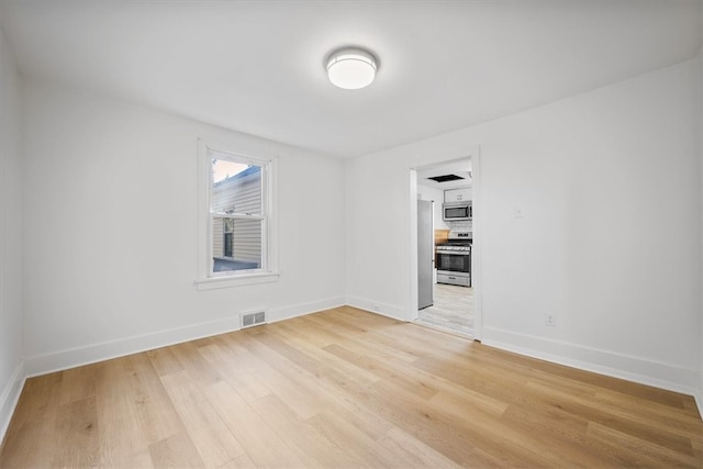 unfurnished room with light wood-type flooring