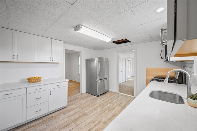 kitchen featuring sink, white cabinetry, stainless steel appliances, and light hardwood / wood-style floors