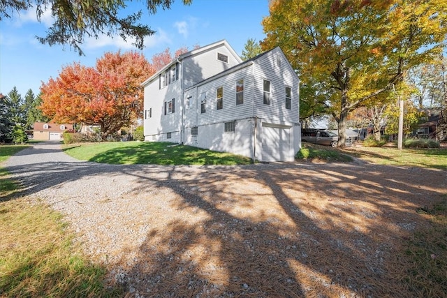 view of side of property with a yard and a garage