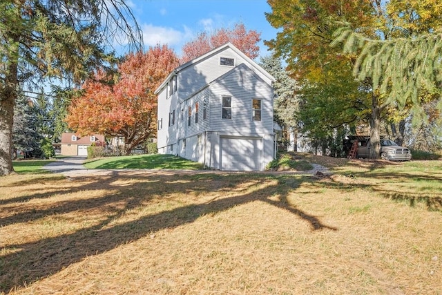 view of side of property with a garage and a lawn