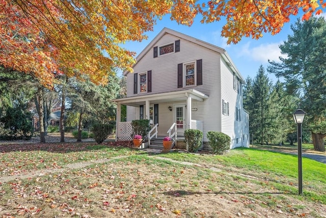 front facade with a front yard and covered porch