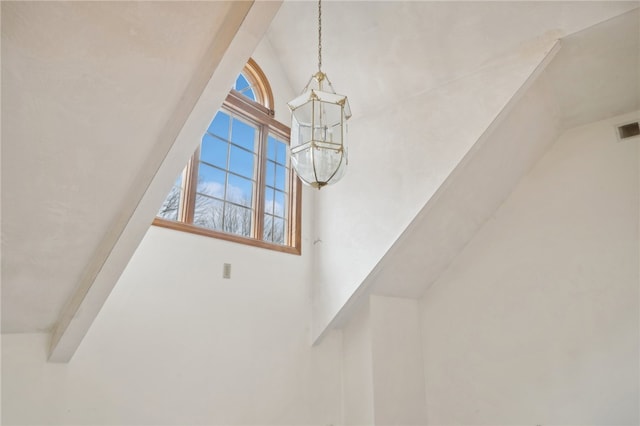 room details with beam ceiling and a notable chandelier