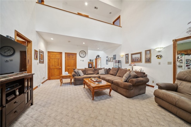 carpeted living room with high vaulted ceiling