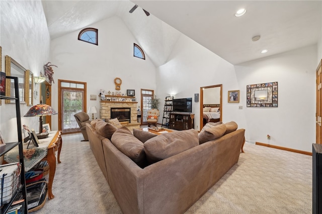 carpeted living room featuring a stone fireplace and high vaulted ceiling