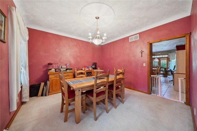 carpeted dining area featuring a notable chandelier