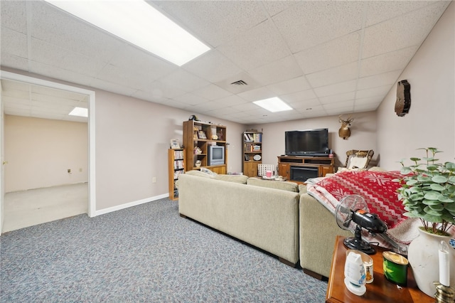 living room featuring carpet and a drop ceiling