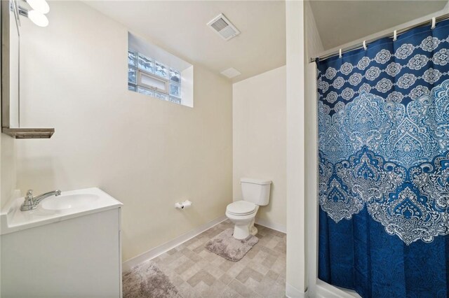 bathroom with vanity, toilet, and walk in shower