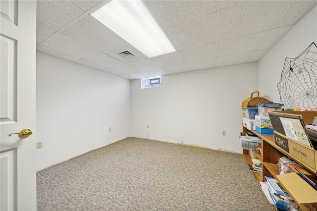 basement featuring a drop ceiling and carpet flooring