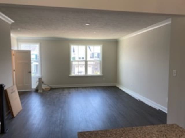 unfurnished living room featuring ornamental molding and dark hardwood / wood-style floors