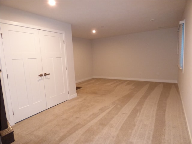 interior space featuring light carpet and a closet