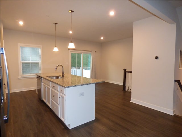 kitchen with appliances with stainless steel finishes, a kitchen island with sink, decorative light fixtures, and dark hardwood / wood-style flooring