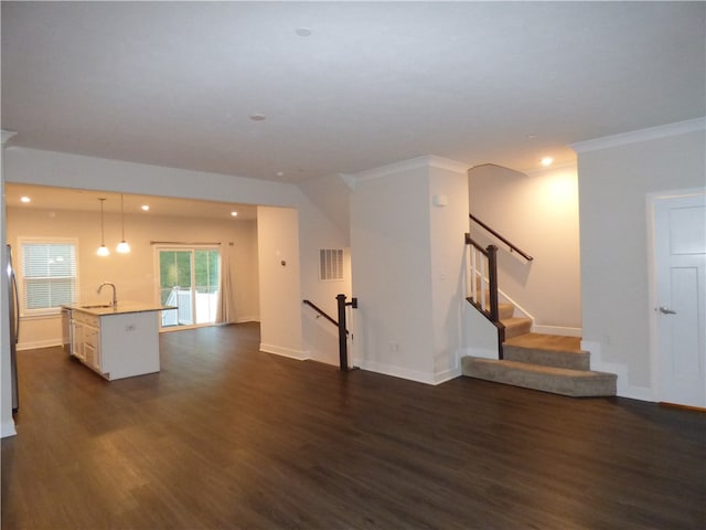 unfurnished living room featuring sink, dark wood-type flooring, and crown molding