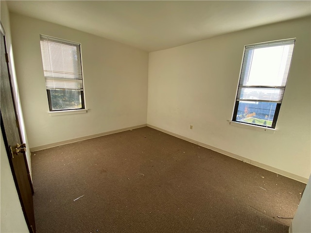 unfurnished room with dark colored carpet