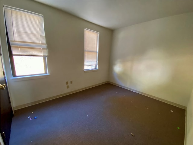 unfurnished room featuring dark carpet