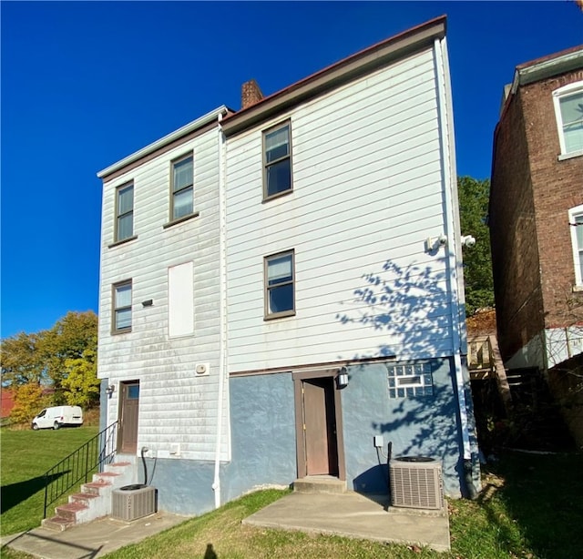 rear view of property with central AC unit