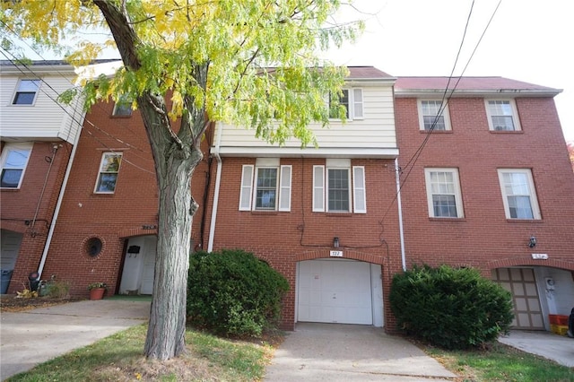 view of front of home with a garage, driveway, and brick siding