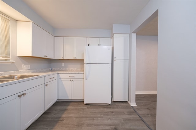 kitchen featuring light hardwood / wood-style flooring, white refrigerator, and white cabinets