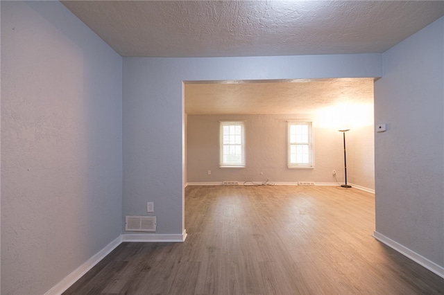 unfurnished room featuring a textured ceiling and hardwood / wood-style flooring