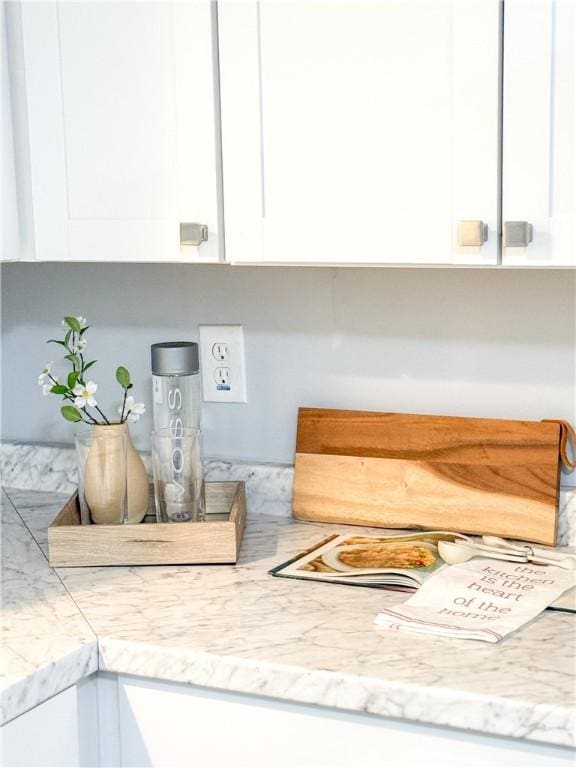 kitchen view of white cabinetry and light stone counters