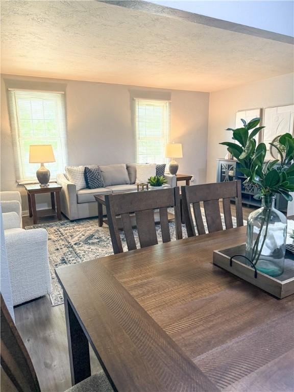 dining area featuring wood finished floors and a textured ceiling