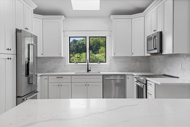 kitchen featuring white cabinets, stainless steel appliances, and sink