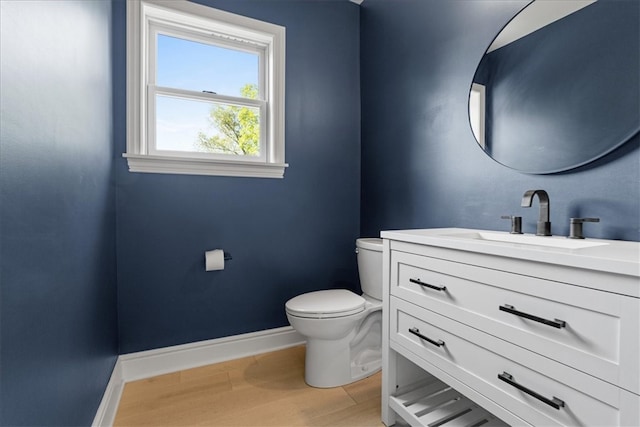 bathroom featuring toilet, hardwood / wood-style flooring, and vanity