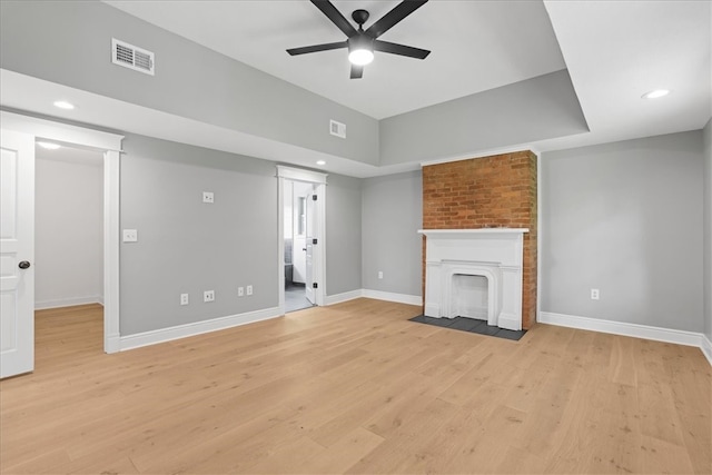 unfurnished living room with light hardwood / wood-style flooring, a fireplace, and ceiling fan