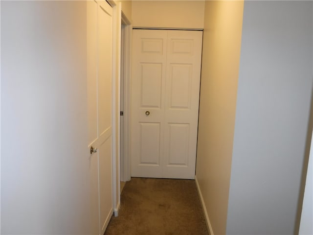 hallway featuring dark carpet