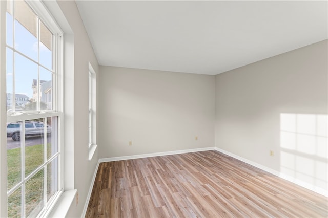 unfurnished room with a wealth of natural light and light hardwood / wood-style flooring