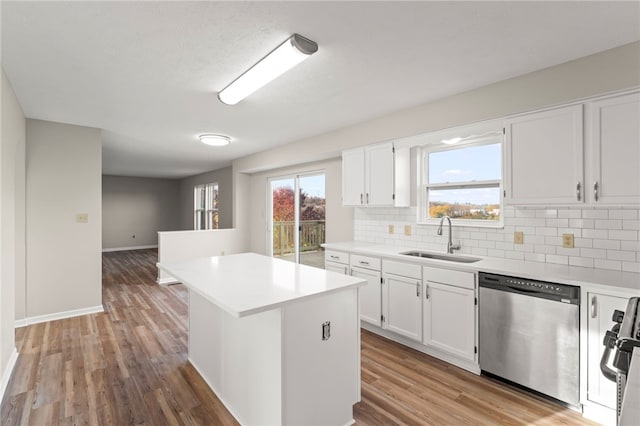 kitchen featuring white cabinets, stainless steel dishwasher, sink, and a kitchen island