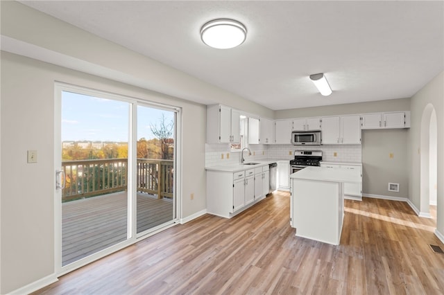 kitchen featuring sink, appliances with stainless steel finishes, white cabinetry, and light hardwood / wood-style floors