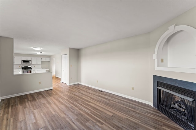 unfurnished living room with dark hardwood / wood-style floors