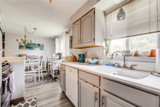 kitchen featuring dishwasher, light hardwood / wood-style flooring, pendant lighting, and plenty of natural light