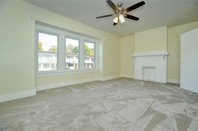 unfurnished living room featuring light carpet, a brick fireplace, and ceiling fan