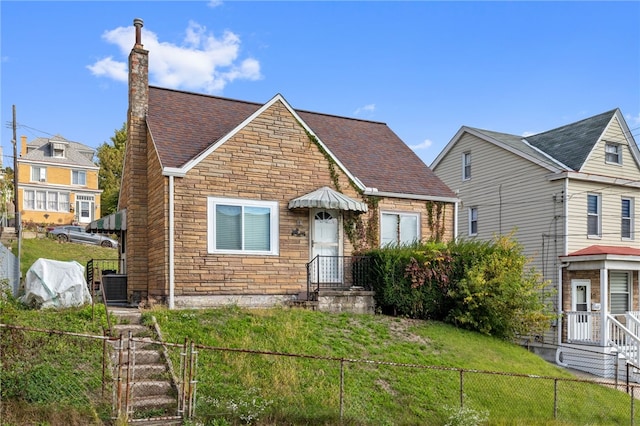 view of front of home with a front lawn and central AC unit