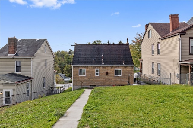 rear view of property featuring a lawn