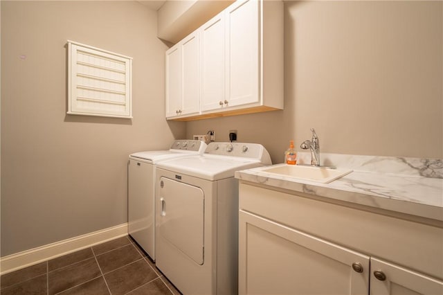 laundry area with cabinets, dark tile patterned flooring, washer and clothes dryer, and sink