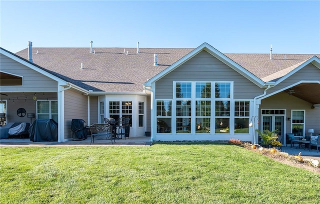 rear view of property featuring a patio area and a lawn