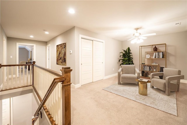 sitting room featuring ceiling fan and light colored carpet