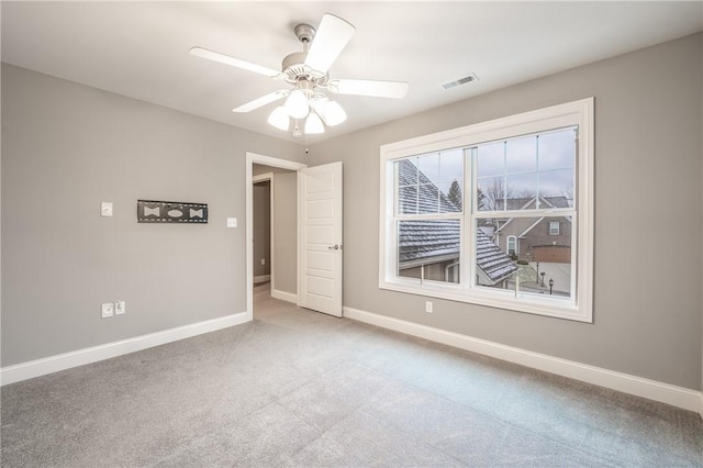 carpeted spare room featuring ceiling fan