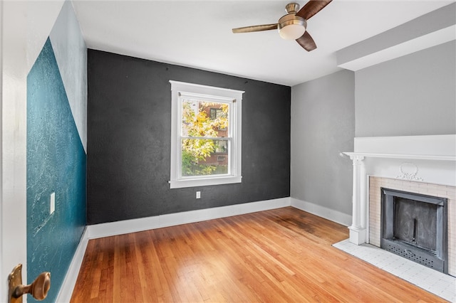 unfurnished living room featuring wood-type flooring, a fireplace, and ceiling fan