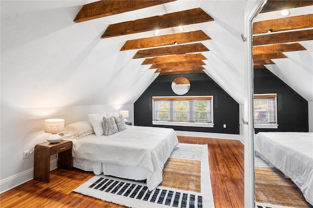 bedroom featuring hardwood / wood-style flooring and lofted ceiling with beams