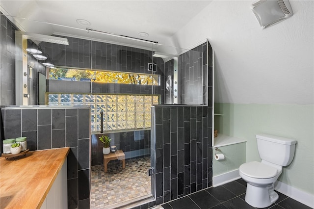 bathroom with tile walls, tile patterned floors, toilet, and an enclosed shower