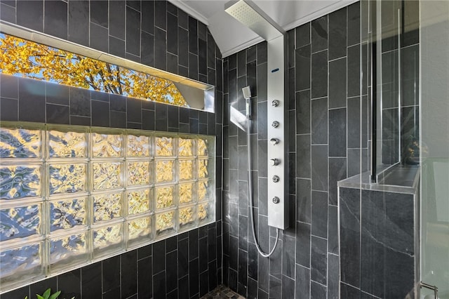 bathroom featuring vaulted ceiling and a tile shower