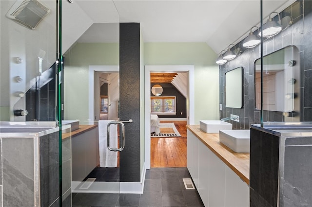 bathroom featuring vanity, lofted ceiling, and hardwood / wood-style flooring