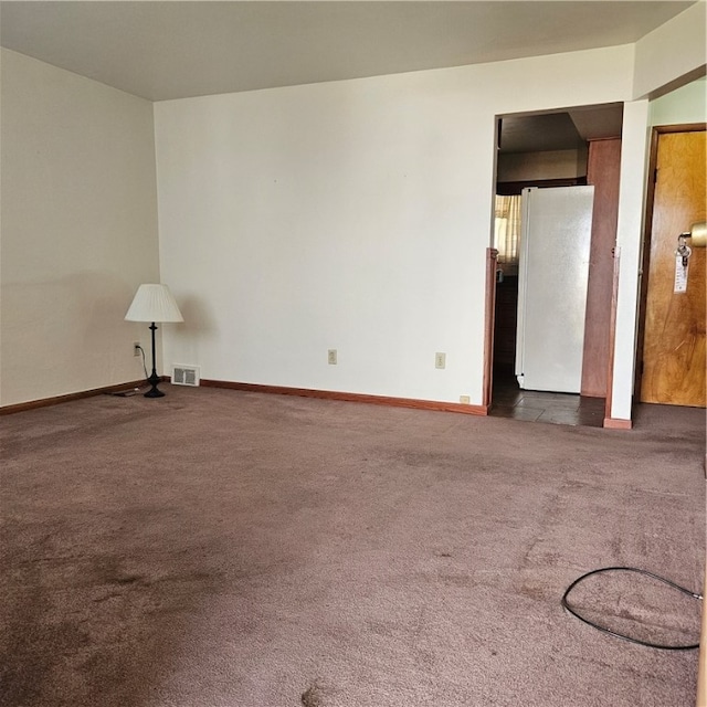 spare room with dark carpet