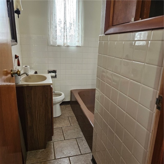 bathroom with tile walls, vanity, toilet, and a bath