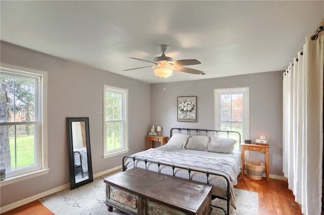 bedroom featuring multiple windows, light wood-type flooring, and ceiling fan