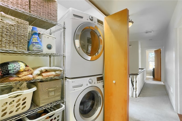 washroom with stacked washer / drying machine and carpet flooring