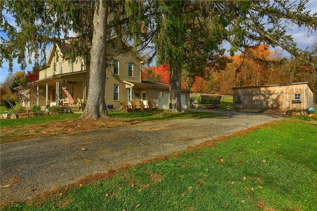 exterior space featuring covered porch, a lawn, and a garage